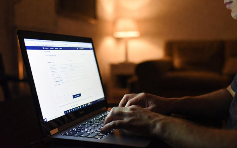 Client envoyant message formulaire contact laptop ambiance chaleureuse