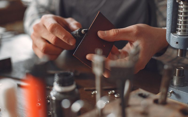 Mains d'artisan qualifié travaillant outil geste précis