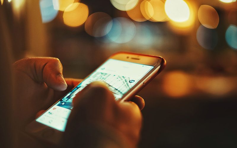 Mains tenant smartphone consultation réseaux sociaux marketing